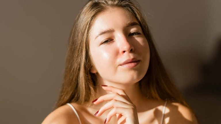 Rostro femenino iluminado por luz natural, con expresión relajada y piel uniforme